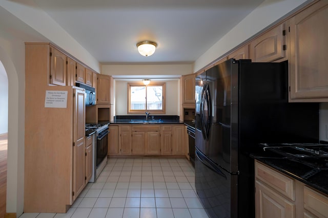 kitchen with light tile patterned flooring, sink, light brown cabinetry, and black appliances