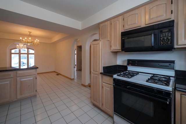 kitchen featuring decorative light fixtures, light brown cabinets, light tile patterned floors, a tray ceiling, and gas range oven