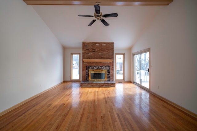 unfurnished living room featuring ceiling fan, lofted ceiling, a fireplace, and light hardwood / wood-style floors