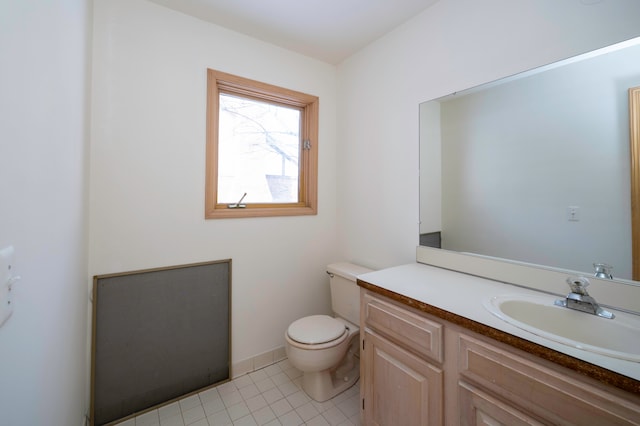 bathroom with tile patterned flooring, vanity, and toilet