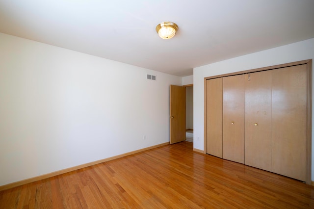 unfurnished bedroom featuring a closet and light hardwood / wood-style flooring