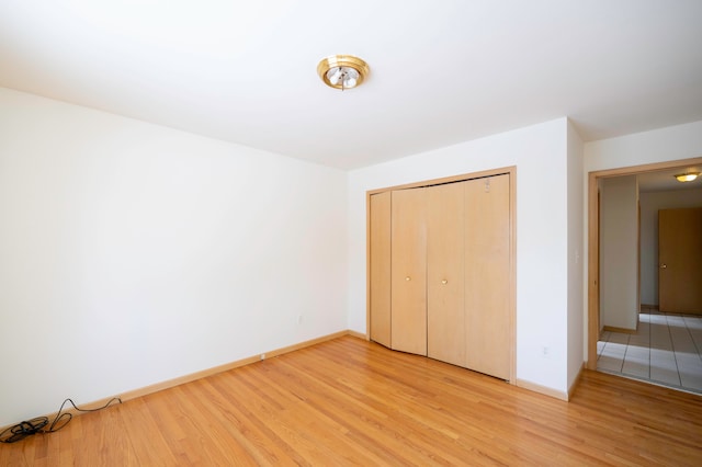 unfurnished bedroom with a closet and light hardwood / wood-style flooring