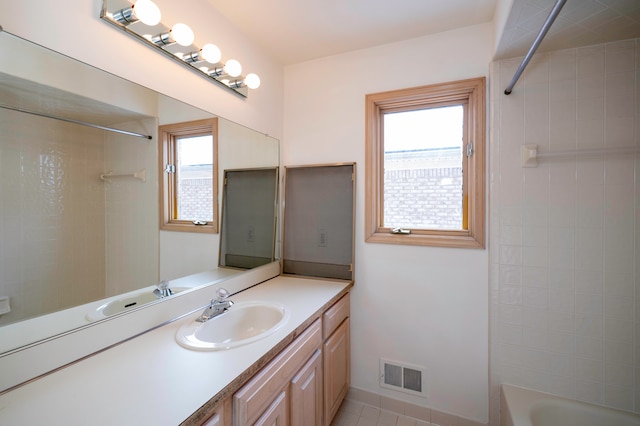 bathroom featuring tiled shower / bath and vanity