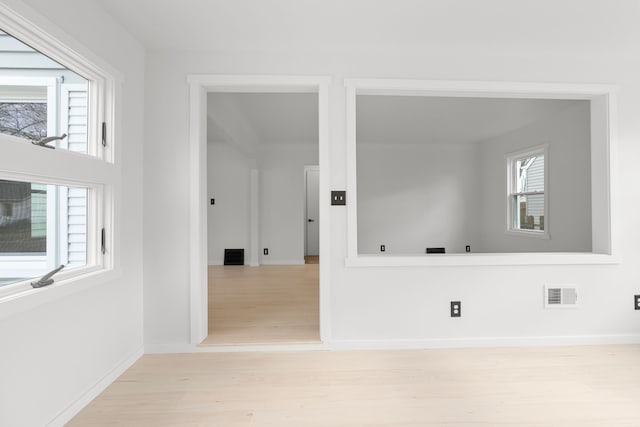 spare room featuring light hardwood / wood-style floors and a healthy amount of sunlight