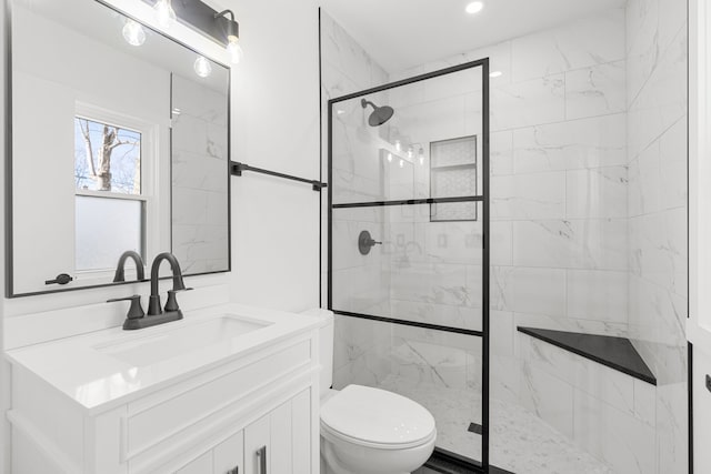 bathroom featuring toilet, vanity, and walk in shower