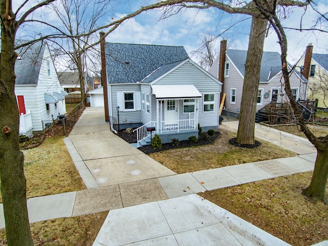 bungalow-style home with a garage, an outbuilding, and a front yard