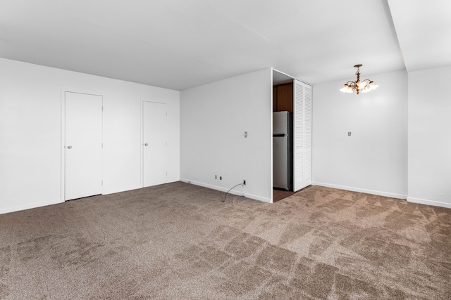 carpeted spare room with a notable chandelier