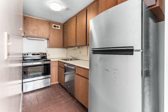 kitchen featuring appliances with stainless steel finishes, sink, and decorative backsplash