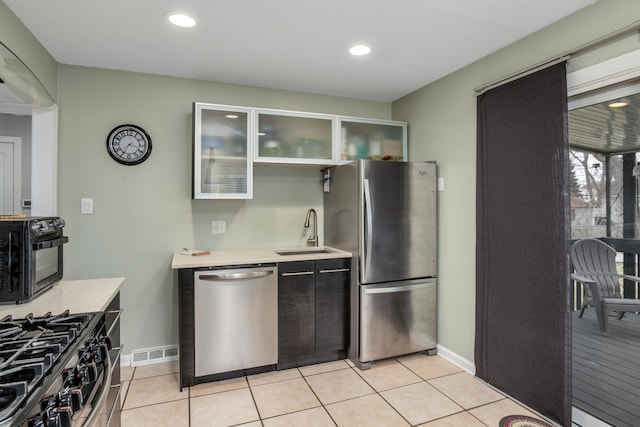 kitchen featuring sink, light tile patterned flooring, and stainless steel appliances