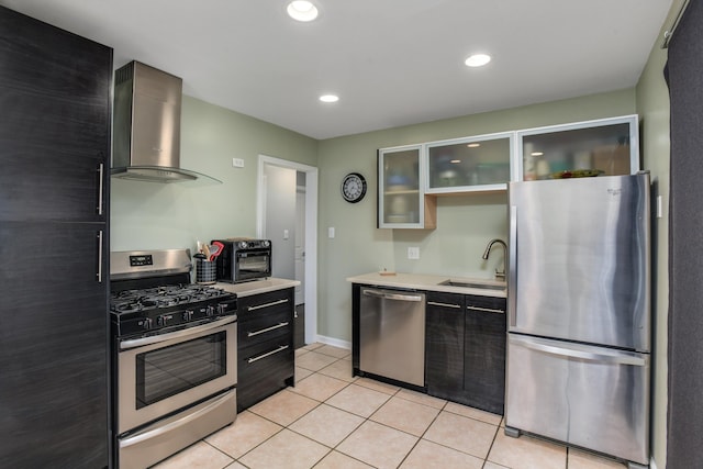 kitchen featuring light tile patterned flooring, wall chimney range hood, sink, and appliances with stainless steel finishes