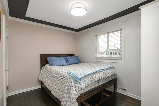 bedroom with dark hardwood / wood-style flooring and ornamental molding