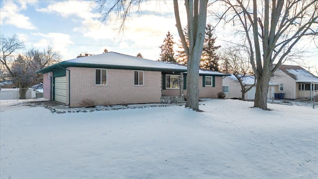 snow covered property with a garage