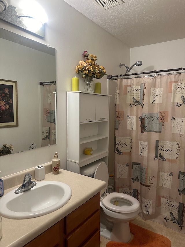 bathroom with vanity, a textured ceiling, tile patterned flooring, toilet, and curtained shower