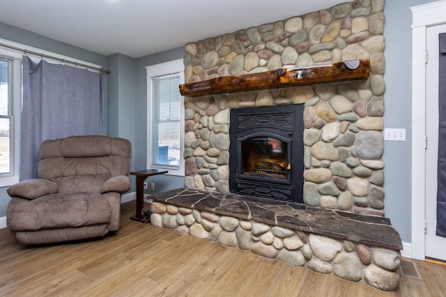 sitting room with light wood-type flooring and a wood stove