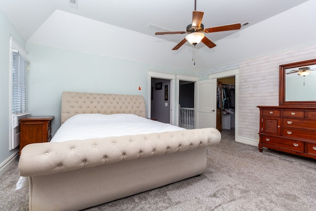 bedroom featuring ceiling fan, light colored carpet, lofted ceiling, a spacious closet, and a closet