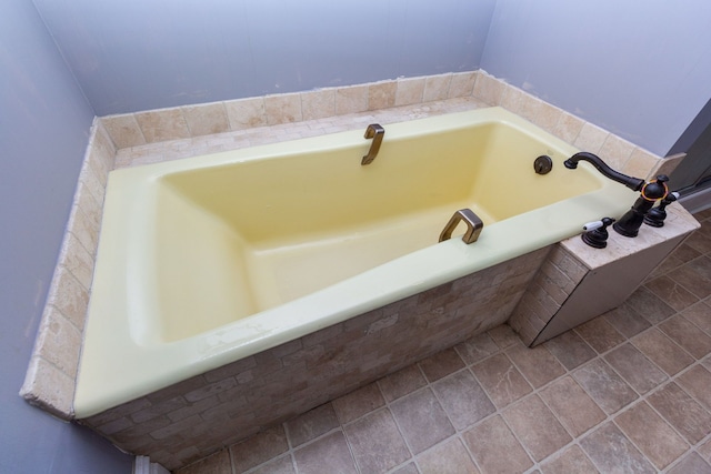 bathroom with tile patterned floors and a relaxing tiled tub