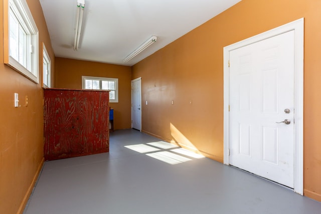 unfurnished room with concrete flooring