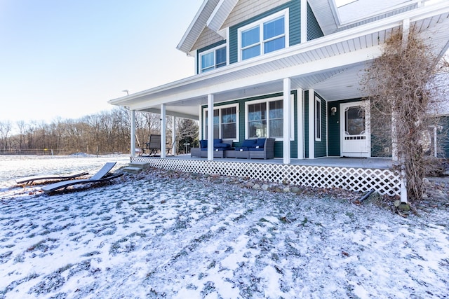 snow covered house with an outdoor hangout area and covered porch