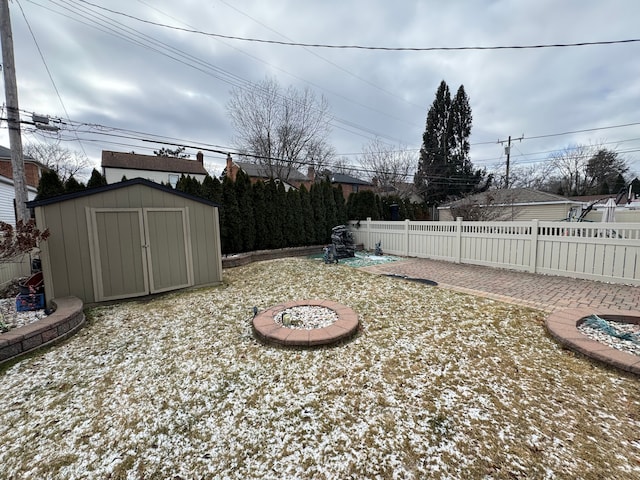 view of yard featuring a storage unit and an outdoor fire pit