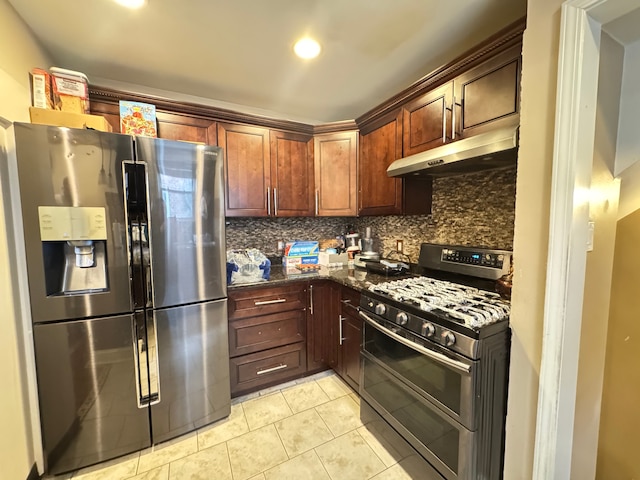 kitchen featuring light tile patterned floors, backsplash, stainless steel appliances, and dark stone counters