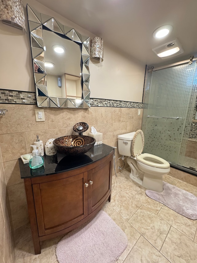 bathroom featuring vanity, tile patterned floors, toilet, tile walls, and walk in shower