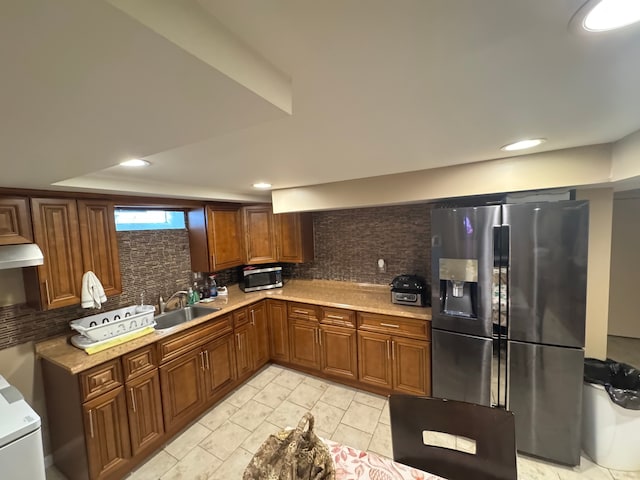 kitchen with backsplash, light stone countertops, sink, and appliances with stainless steel finishes