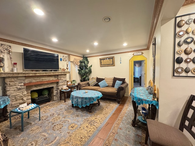 living room featuring a fireplace, hardwood / wood-style floors, and crown molding