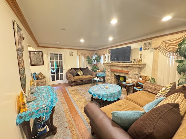 living room featuring a fireplace, hardwood / wood-style floors, and crown molding