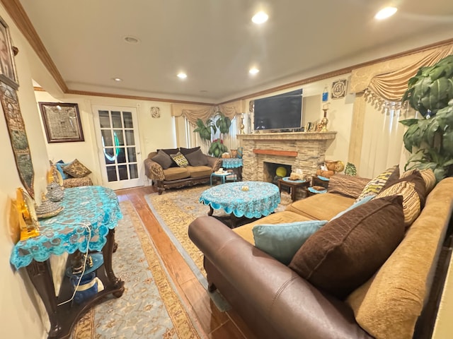 living room with a fireplace, ornamental molding, and hardwood / wood-style flooring