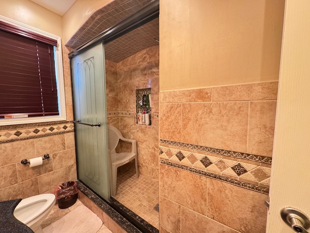 bathroom featuring a shower with door, tile patterned flooring, tile walls, and toilet