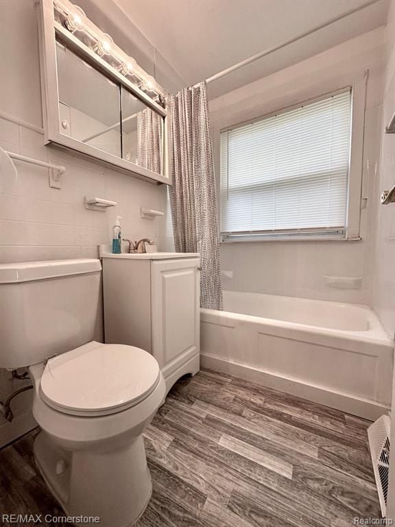 full bathroom with vanity, shower / bathtub combination with curtain, wood-type flooring, and toilet