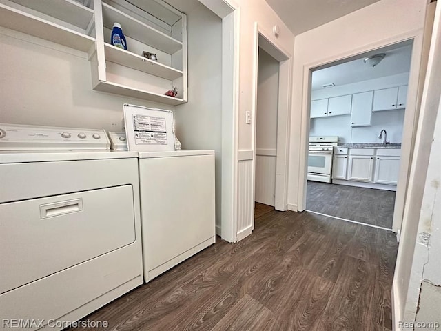 washroom featuring washer and clothes dryer, dark wood-type flooring, and sink