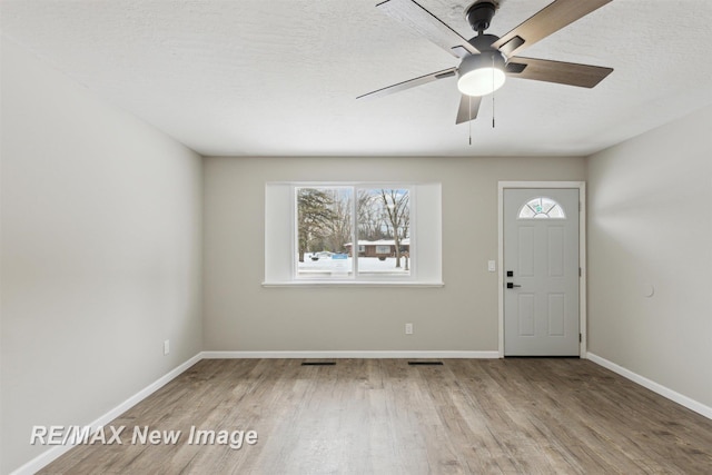 foyer featuring ceiling fan, plenty of natural light, hardwood / wood-style floors, and a textured ceiling