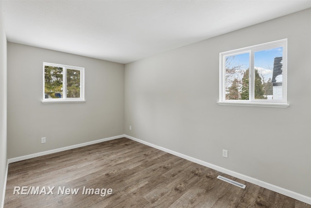 unfurnished room with wood-type flooring