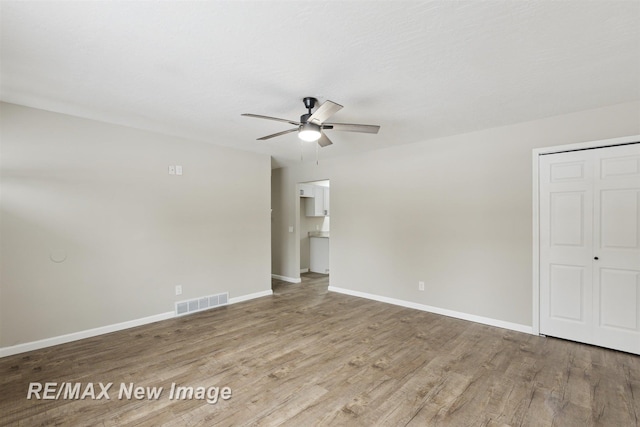 spare room with ceiling fan and light wood-type flooring