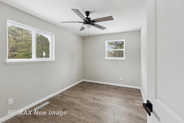 spare room featuring a wealth of natural light, ceiling fan, and hardwood / wood-style flooring