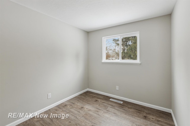 empty room with hardwood / wood-style flooring