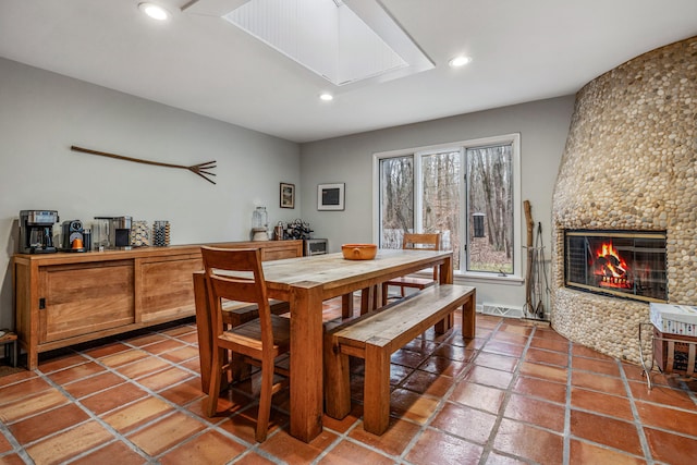 dining room with tile patterned floors and a large fireplace