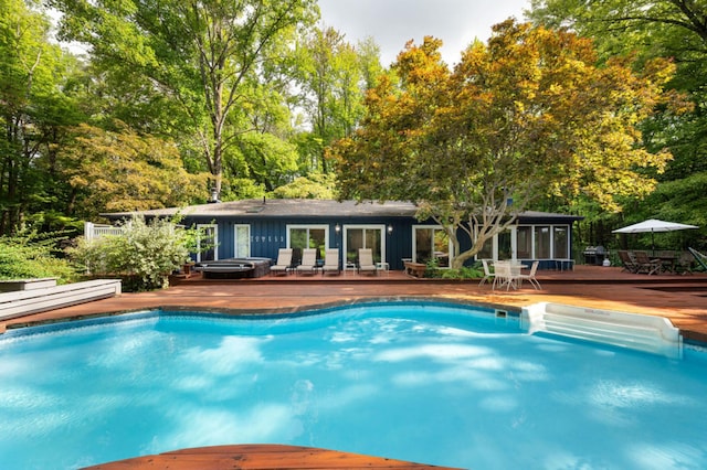 view of swimming pool with a sunroom and a deck