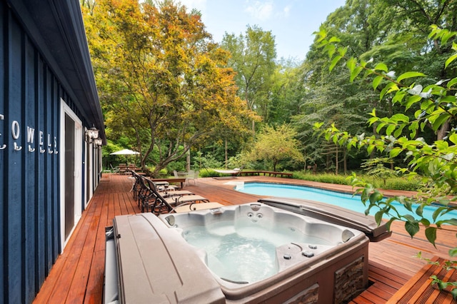 view of swimming pool with a wooden deck and an outdoor hot tub