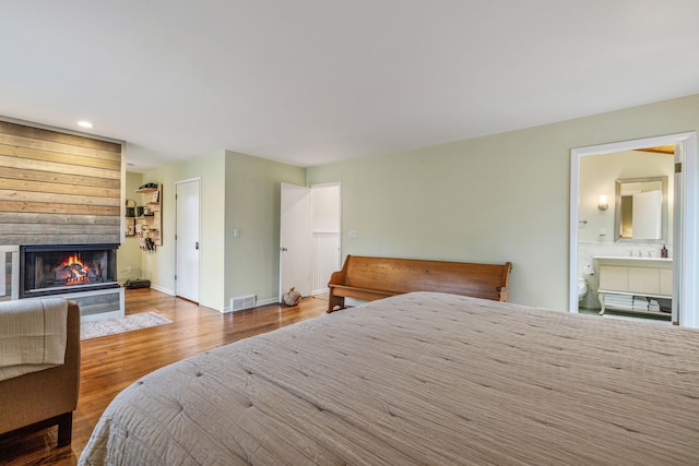 bedroom featuring ensuite bathroom and hardwood / wood-style flooring