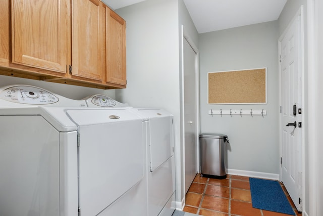 clothes washing area with dark tile patterned floors, cabinets, and independent washer and dryer