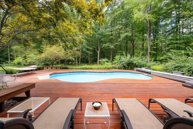 view of swimming pool featuring a diving board and a deck