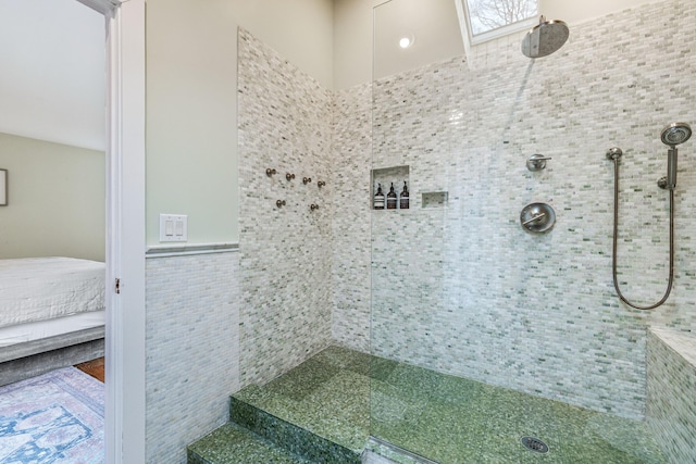 bathroom with tiled shower and tile walls