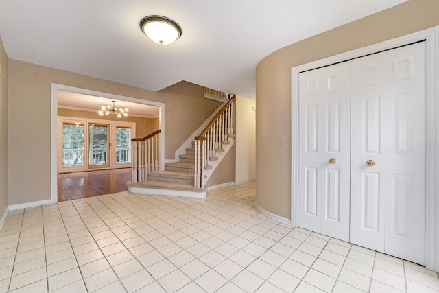 tiled foyer entrance with a chandelier