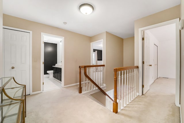 hallway featuring light colored carpet