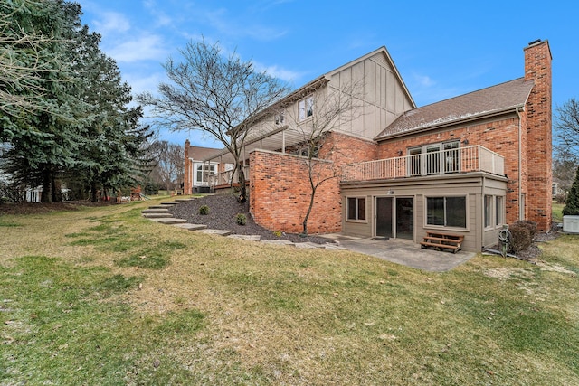 rear view of property with a yard, a balcony, and a patio area