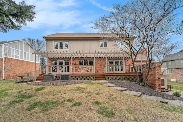 back of property with a lawn, a deck, a pergola, and central air condition unit