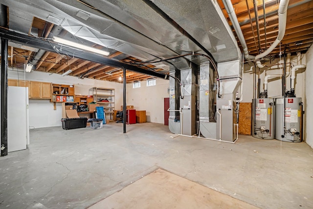 basement featuring white refrigerator, heating unit, and water heater