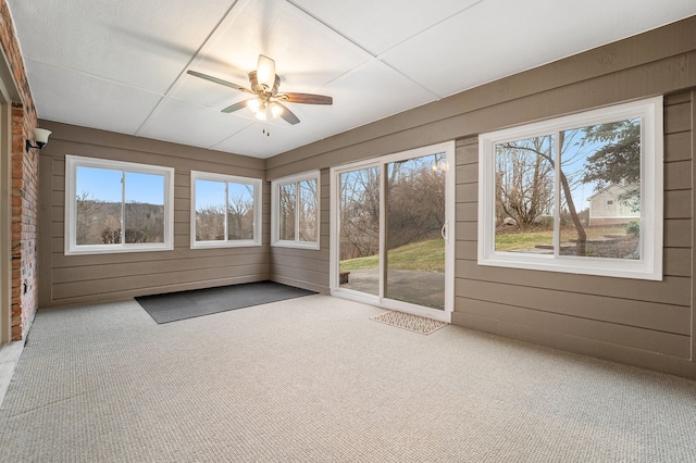 unfurnished sunroom with ceiling fan